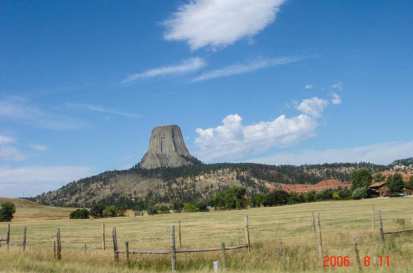 Devils Tower rising above a fenced pasture