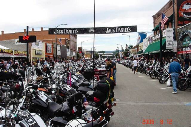 A crowded Sturgis main street lined with motorcycles during the rally