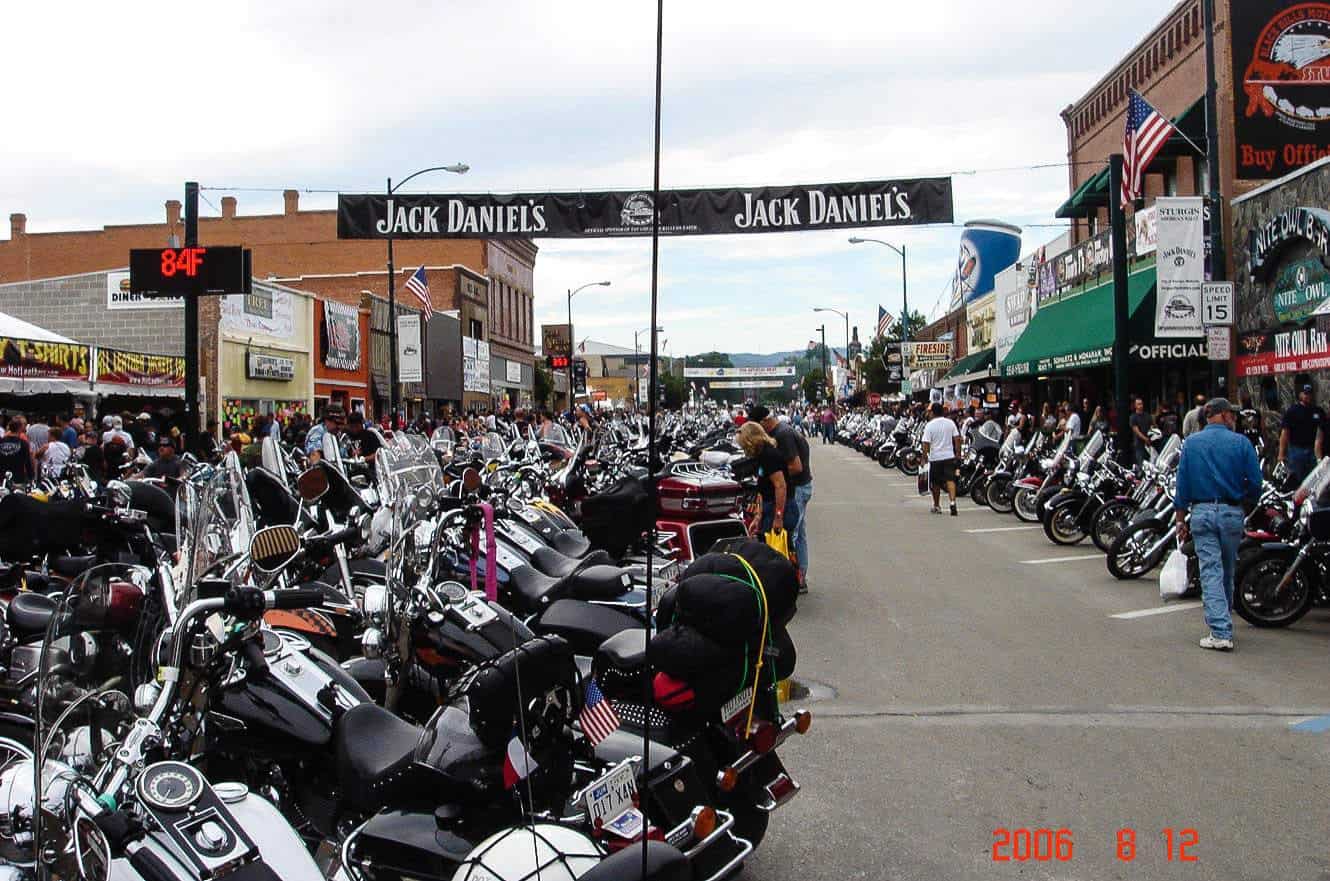 A crowded Sturgis main street lined with motorcycles during the rally