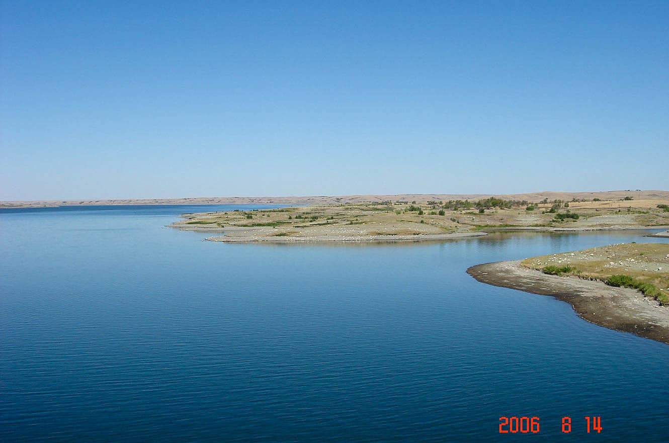 Another view of the blue lake and a distant tree-lined peninsula