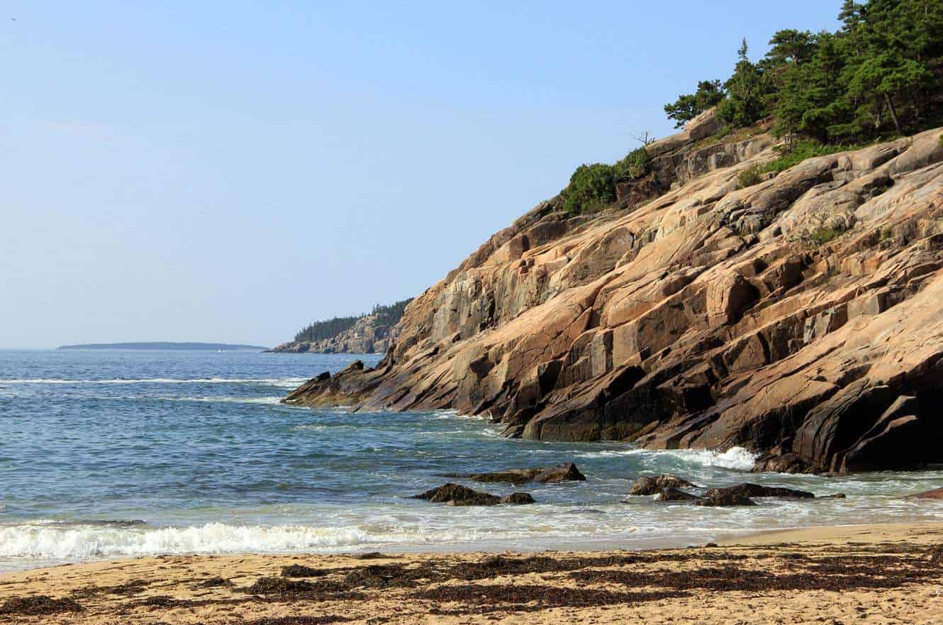 The pink granite cliffs and rocky shoreline of Sand Beach in Acadia National Park