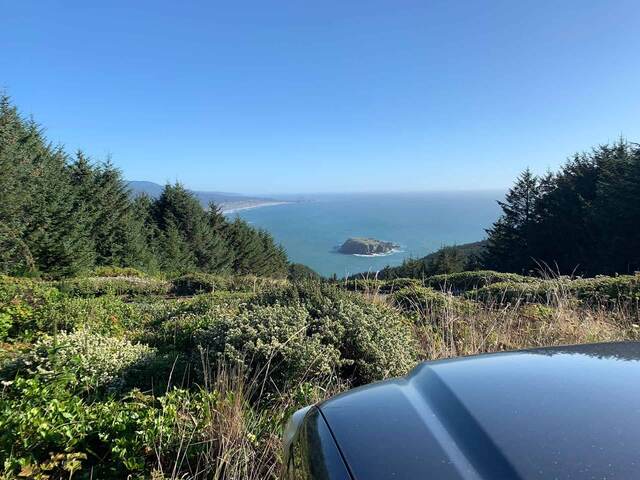 View of the Oregon coastline and a rocky sea stack from a car parked along Cape Sebastian