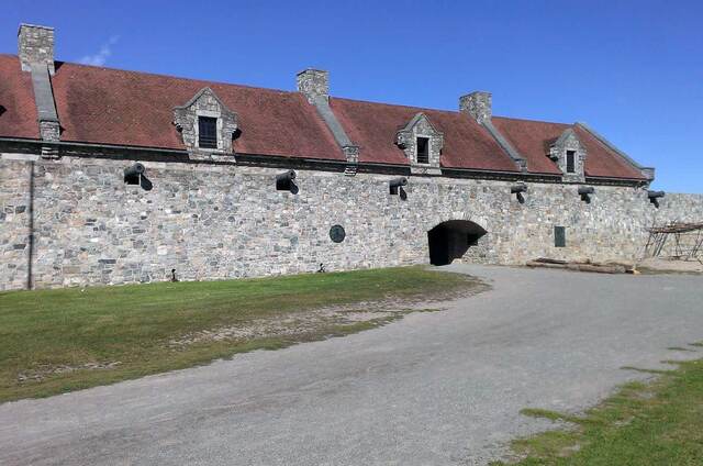 The restored stone barracks building at Fort Ticonderoga with its dormer windows and red tile roof