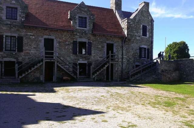 The fort's stone barracks building with wooden staircases leading to the upper floor entrances