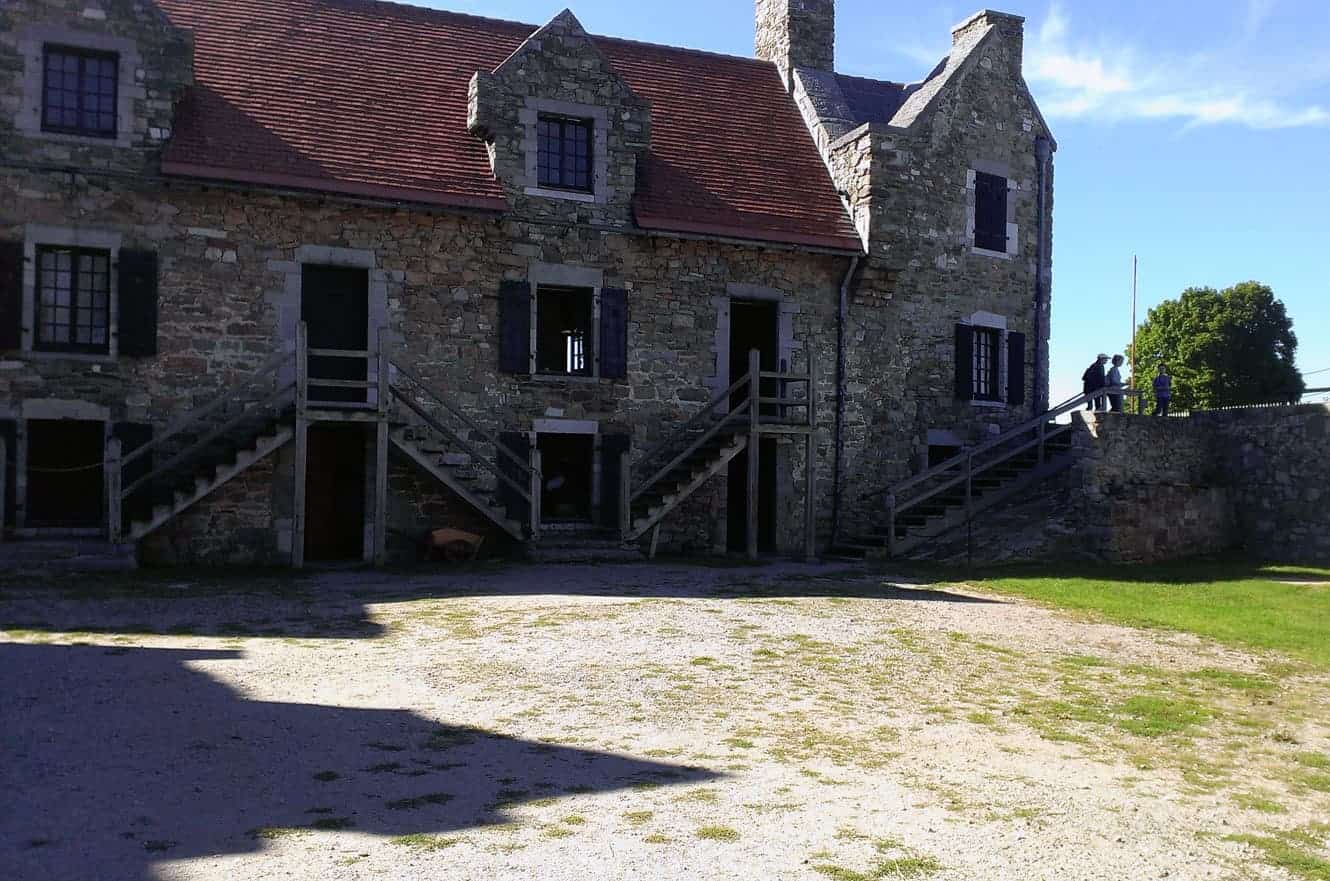 The fort's stone barracks building with wooden staircases leading to the upper floor entrances