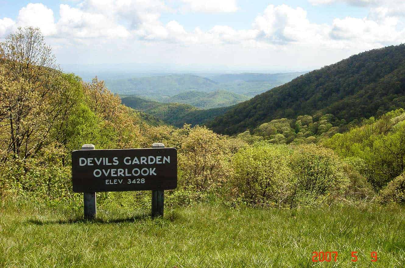 The Yadkin Valley Overlook sign on the Blue Ridge Parkway, looking out over hazy forested ridgelines