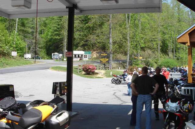 Motorcycles parked at the Tail of the Dragon stop in Deals Gap, North Carolina, with riders gathered nearby