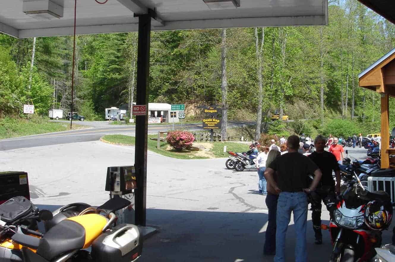 Motorcycles parked at the Tail of the Dragon stop in Deals Gap, North Carolina, with riders gathered nearby
