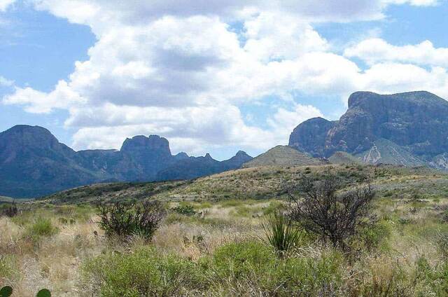 Layered desert peaks of the Chisos Mountains rising above a scrub-covered basin in Big Bend National Park