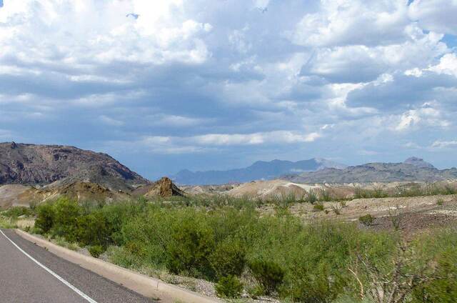 Badlands and distant desert mountains along the road leaving Big Bend National Park