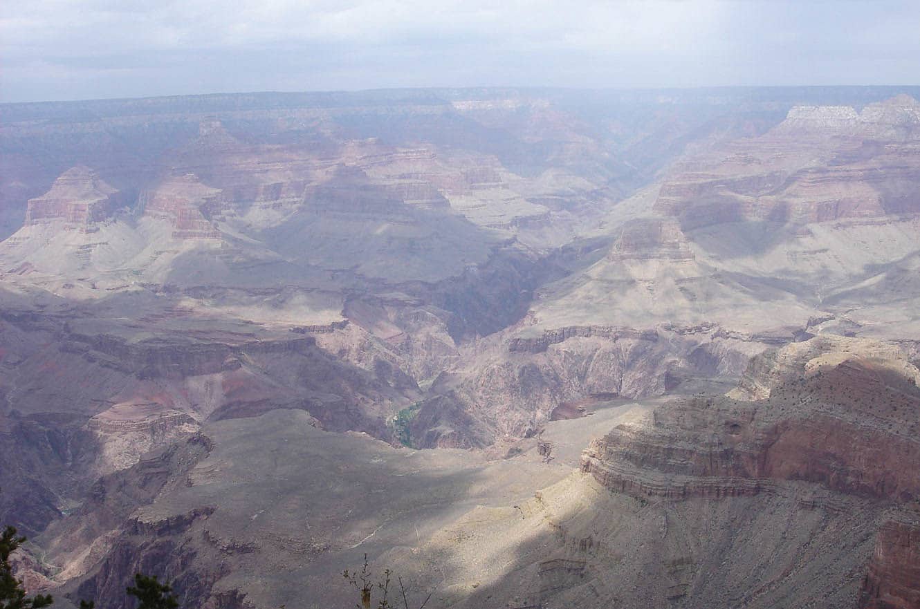 A hazy, overcast view into the layered rock formations of the Grand Canyon