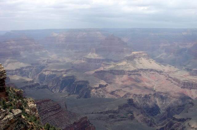 A hazy panorama of buttes and mesas across the Grand Canyon
