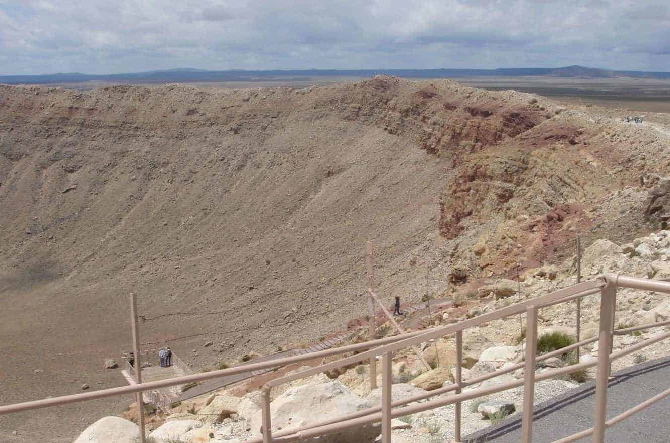 Visitors on a viewing platform overlooking the steep walls of Meteor Crater