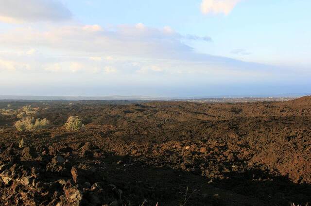 A vast black lava field stretching toward the distant coast