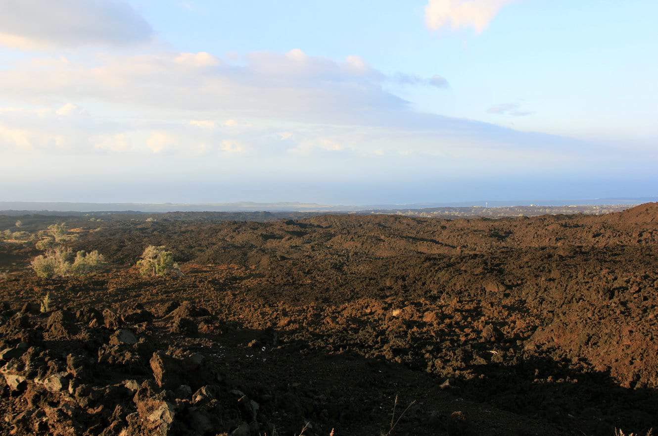 A vast black lava field stretching toward the distant coast