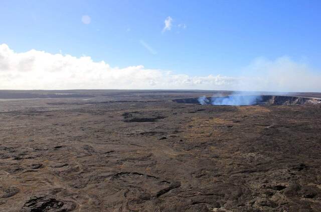 A wider view of the smoking Halemaʻumaʻu crater across the caldera floor