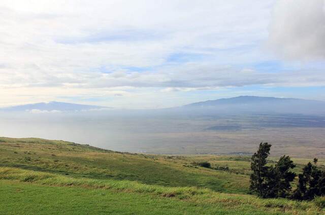 A hazy view across the saddle between Mauna Kea and Mauna Loa from the pasture