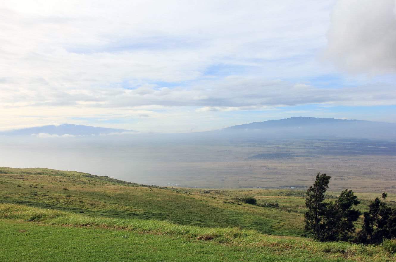 A hazy view across the saddle between Mauna Kea and Mauna Loa from the pasture