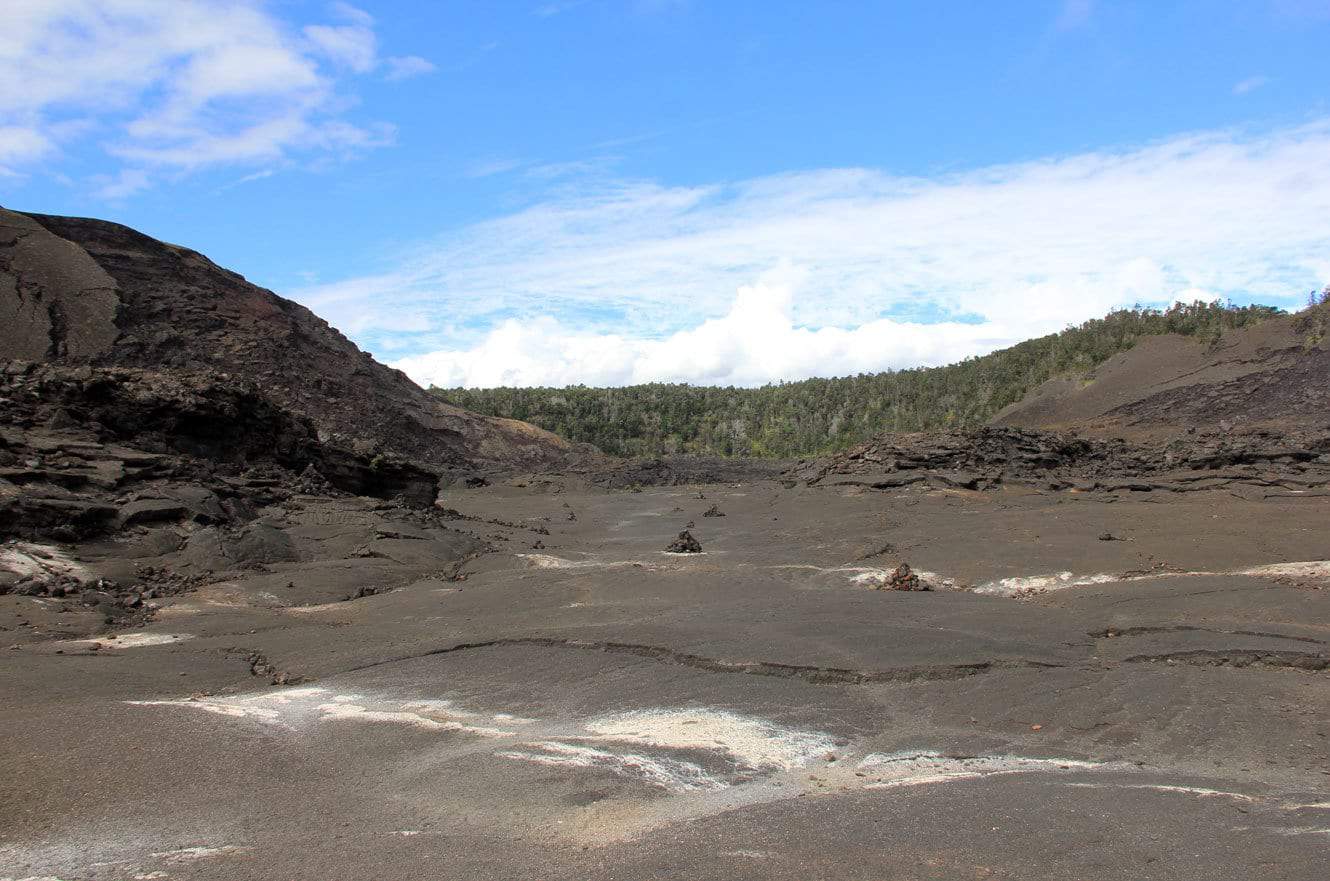 Crossing the flat lava floor of the Kilauea Iki crater toward the forested far wall