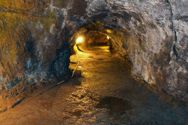 Inside the illuminated Thurston Lava Tube, the tunnel curving ahead