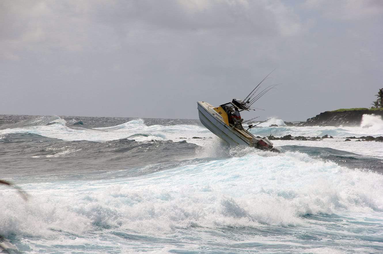 The fishing boat getting airborne off a wave near the rocky point
