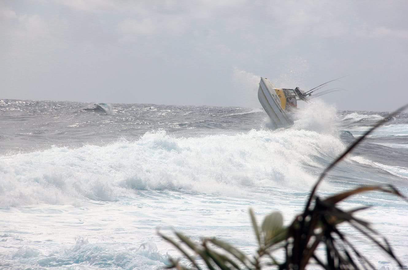 The boat nearly flipping backward as it launches off a large breaking wave